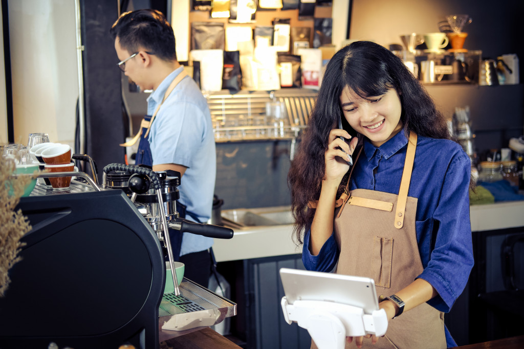 Barista talking order by phone in her shop