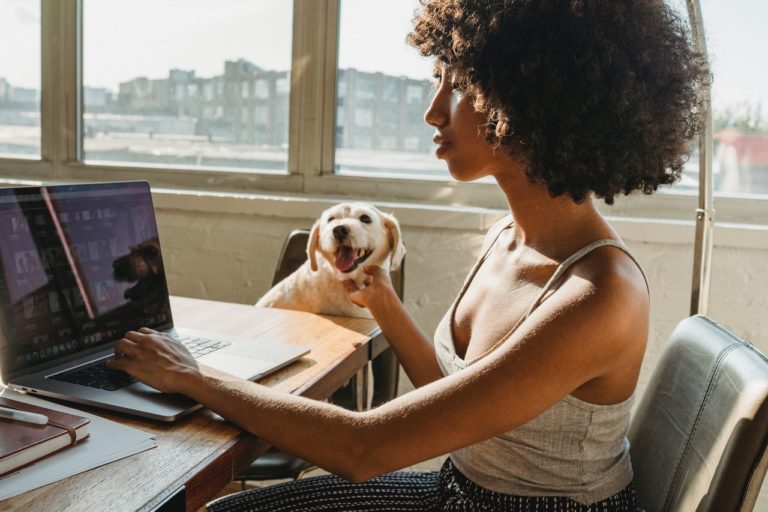 woman using her computer with her dog