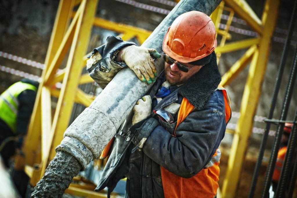 man holding a gray pipe