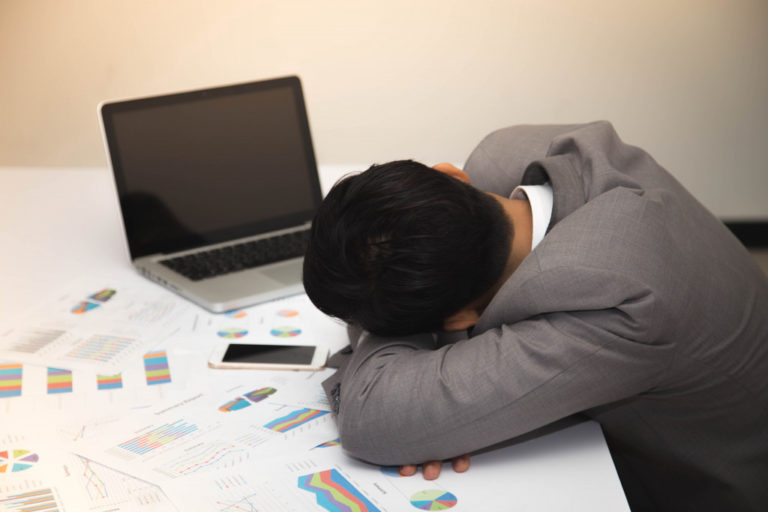 employee dozing off with his heads down on a table