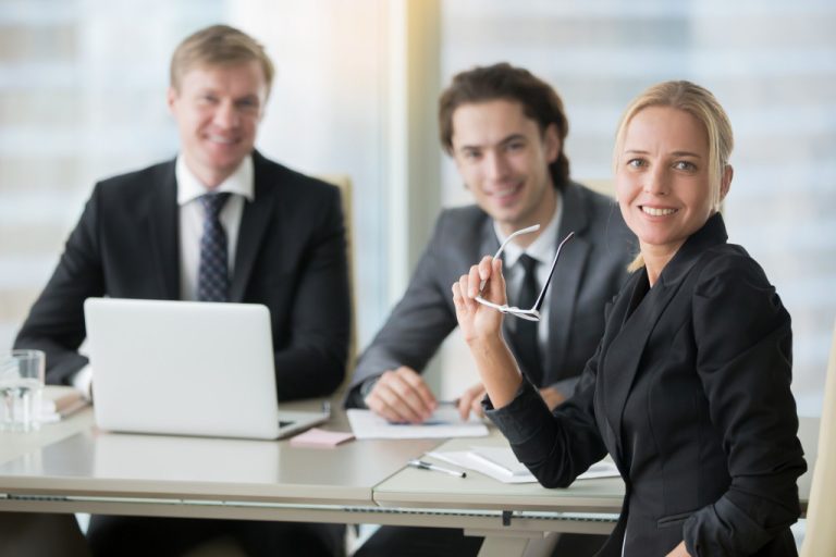 Group of professionals sit at a table in the office