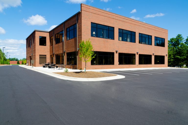 Side view on the generic red brick office building with parking lot