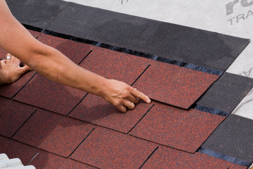 a man placing shingles in a roof